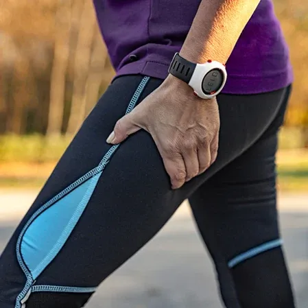 A woman with sciatica pain holding her leg