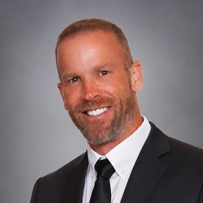Chris Price smiling in a chiropractic clinic